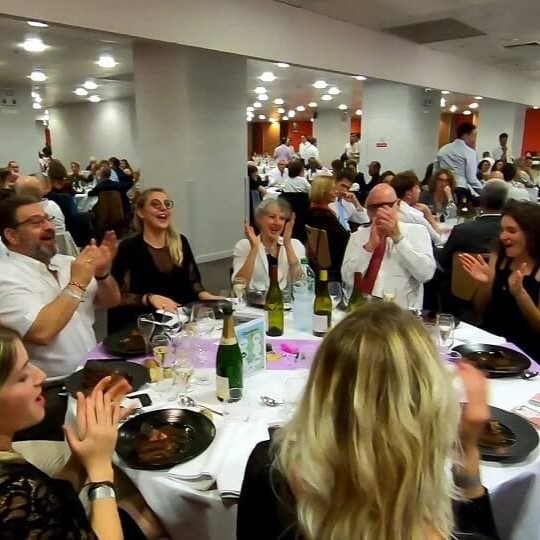 Surprise et magie lors d'un séminaire d'entreprise devant un public qui applaudit